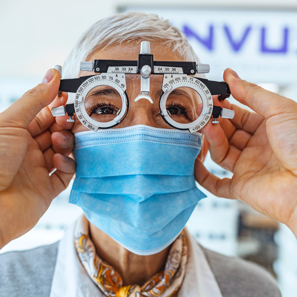 Old lady wearing mask and giving eye test